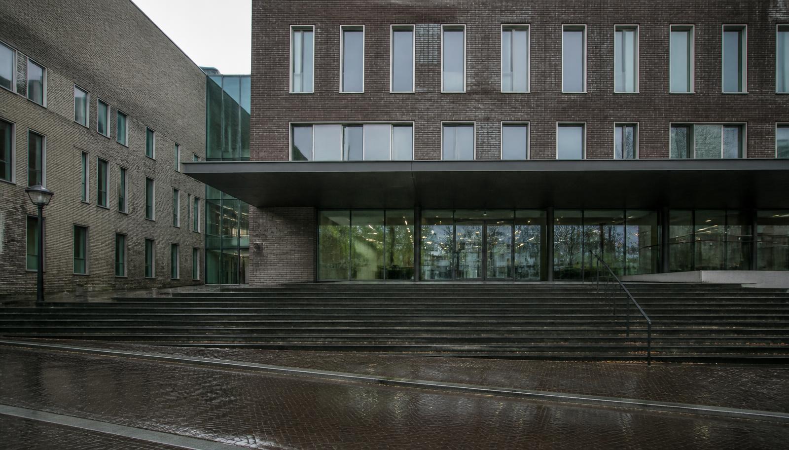 Ingang van een Nederlandse rechtbank op een regenachtige ochtend, waar insolventies officieel worden gepubliceerd